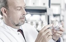 Vedec drží nádobku s krémom Eucerin