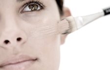 Žena pri nanášaní mejkapu štetcom