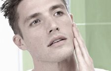 Muž sa dotýka ľavého líca