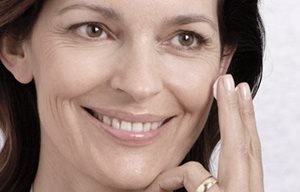 Žena aplikujúca krém na tvár.