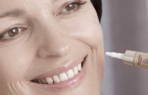 Žena aplikujúca krém Eucerin na ľavé líce.