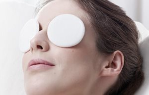 Žena odpočíva s vatovými tampónikmi na očiach