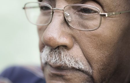 Starší muž s tmavou pleťou a viditeľnými nosoperovými ryhami