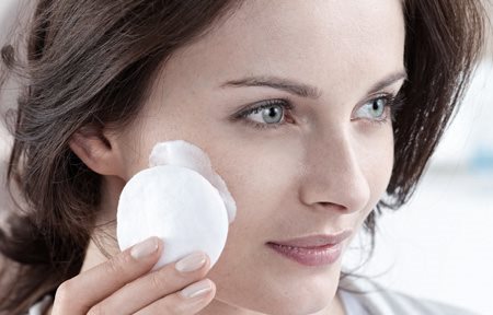 Žena pri čistení pleti odličovacím tampónom