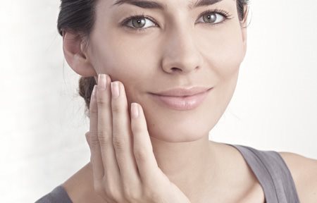 Žena aplikujúca krém na tvár 